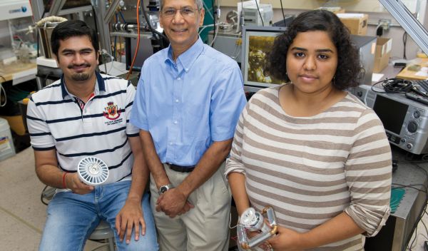 Photo of Ankit Kalani, Satish Kandlikar and Kirthana Kripash holding a LED light cooling device.
