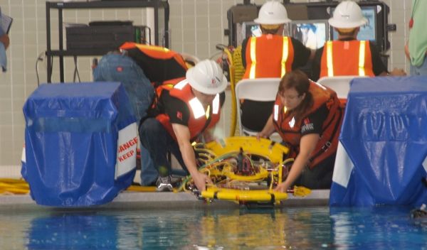 Photo of two Long Beach City College ROV Team members launching the ROV in the pool.