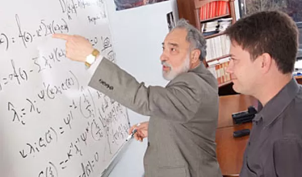 Photo of two men in at a whiteboard