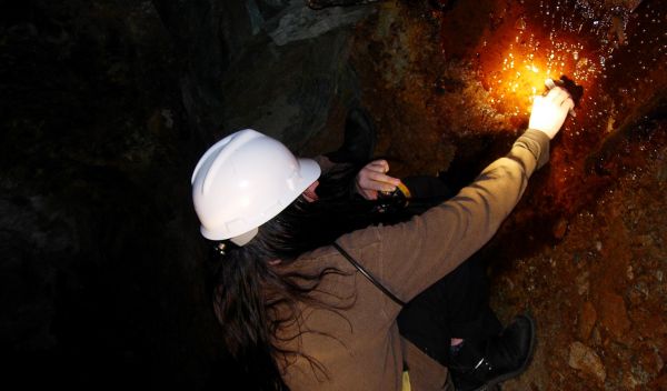 Photo of a  researcher collecting a sample at a mine for microbial analysis.