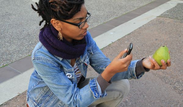 Photo of a young woman taking a photo for a paper prototype used to demonstrate the Forage City app.