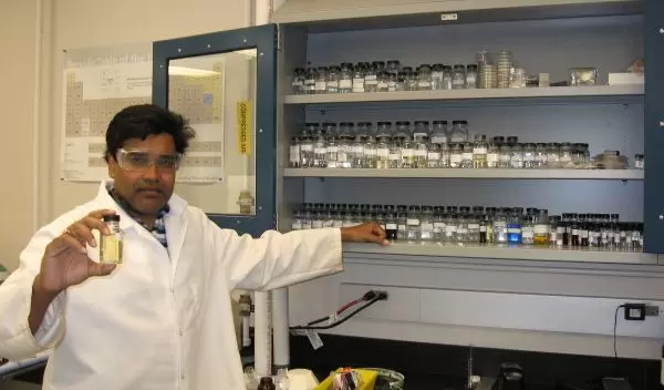 Photo of Sudipta Seal holding a bottle containing billions of ultra-small, engineered nanoceria.