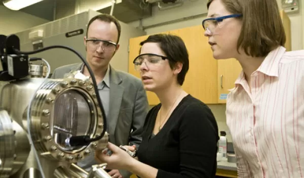 Photo of Charles Sykes and two graduate students using a scanning tunneling microscope.