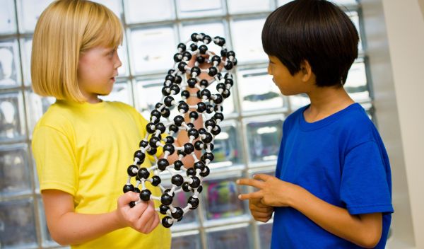 Photo of children talking about a model of a carbon nanotube.