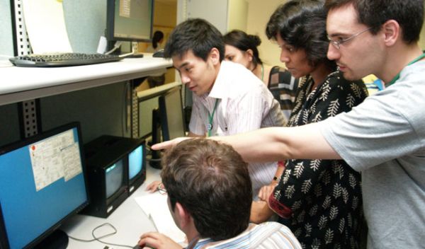 Photo shows Exotic Beam Summer School students viewing progress of their experiments.