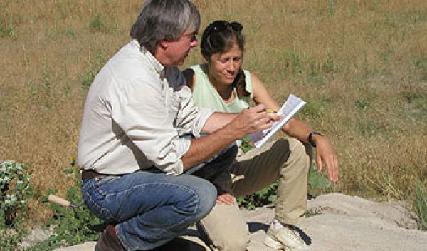 Two researchers hover over field notes.