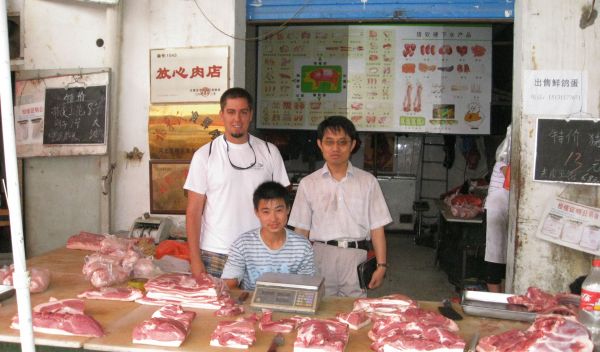 Photo of David Ortega and Laping Wu with a pork seller in Shijiazhuang, Hebei Province, China.