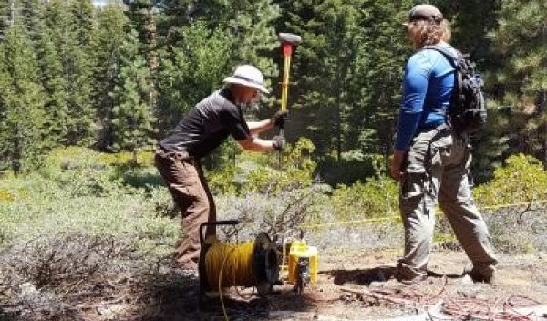 Alec Spears (left) and Troy Covill collecting seismic refraction data from geophones