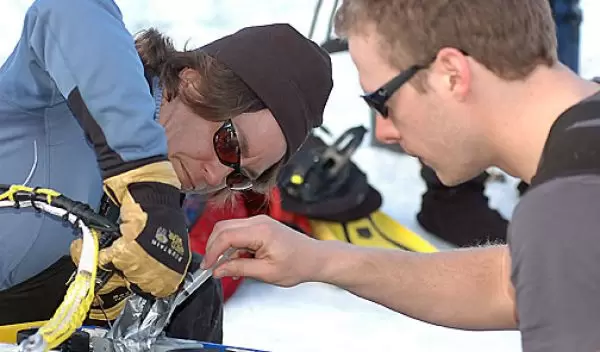 Photo shows Gretchen Hofmann and Tom Crombia carrying out a "field repair" on the rover.