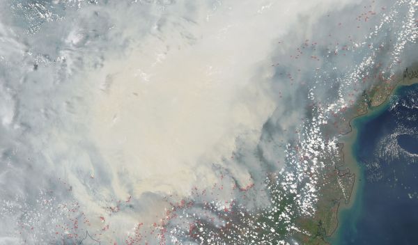thick gray smoke hovers over the Southeast Asian island of Borneo