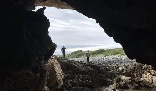 research team members standing at the entrance of a cave