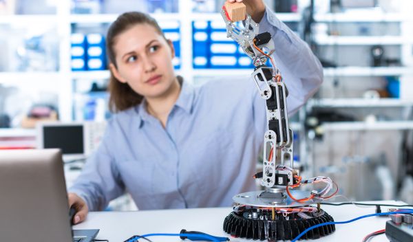 Woman in a laboratory experimenting with a robot