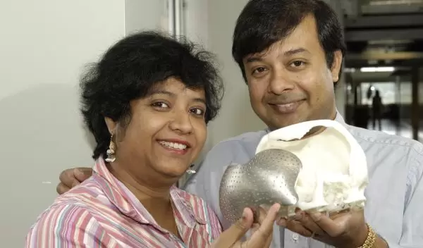 Engineers holding a skull with artificial implant