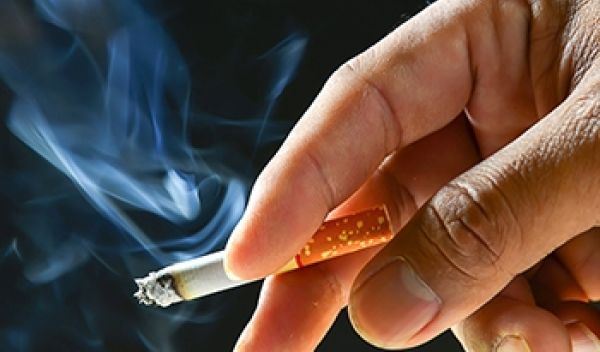 a lit cigarette between a person's fingers