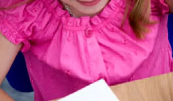 Photo of a young girl using a ruler on a piece of paper.