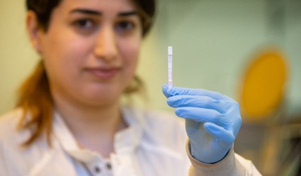 research assistant holds up a sensor