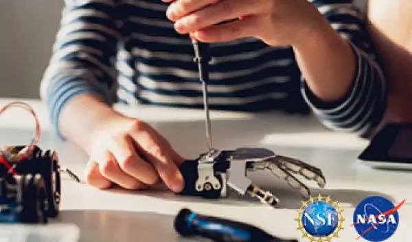 female putting together a robot hand with NSF NASA logos placed on top