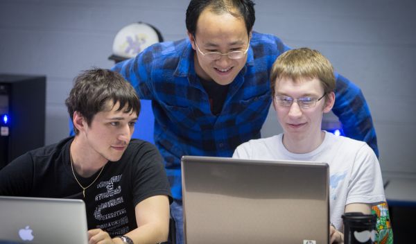professor Yunsheng Wang working with two students.