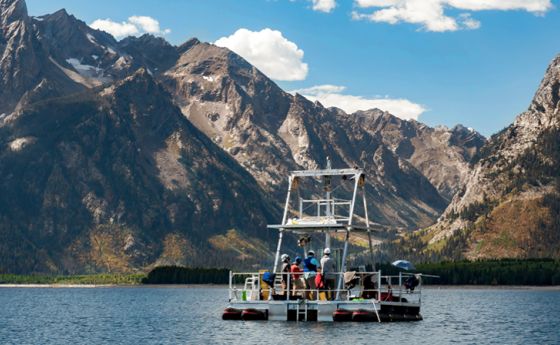 a boat in a body of water with a mountain background