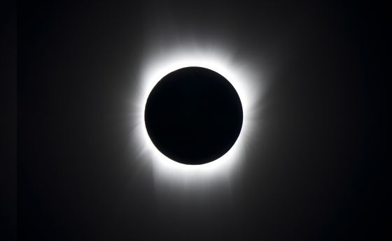Image of a total eclipse, with the moon fully occluding the sun, surrounded by a corona of glowing light.
