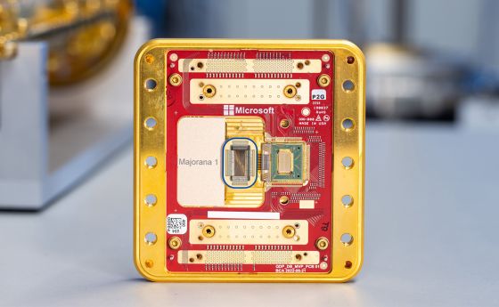 A gold and red rectangular computer chip with many small wires and other electronic components.