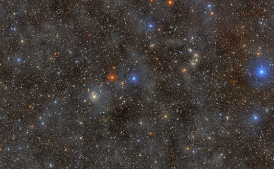 A dense field of colorful stars shining through a dust cloud