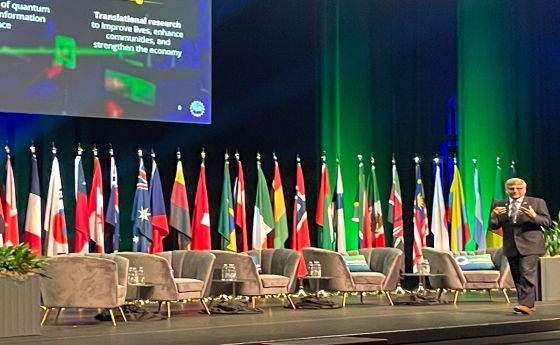 man standing on large stage giving a presentation