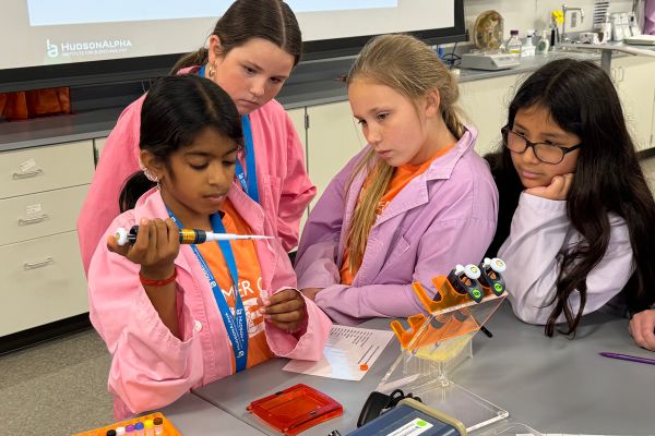 a group of 4 female students engaged in a science project