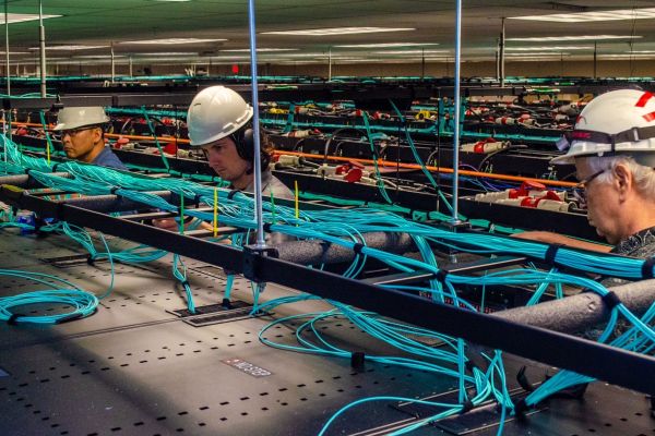 employees work on the network cabling above the racks of Frontera.