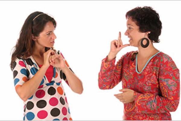 Two women communicate using sign language.