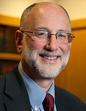 portrait of man wearing glasses in a suit and tie